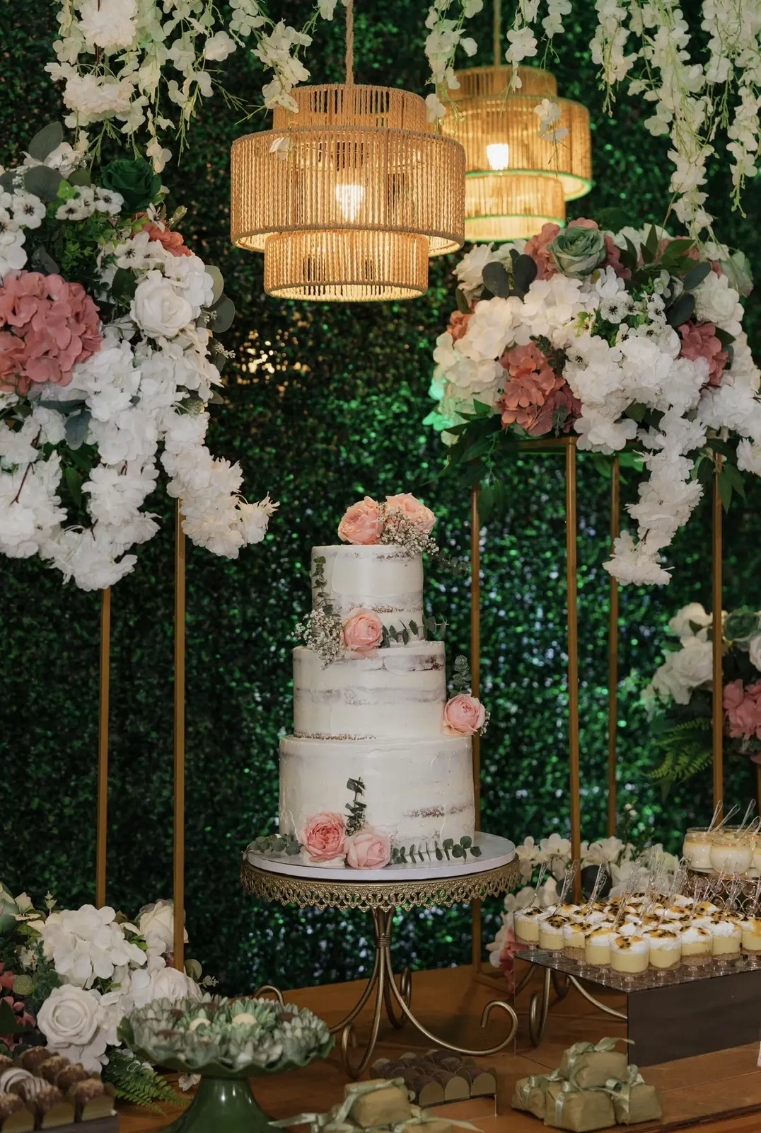 Mesa de bolo com flores brancas e detalhes dourados